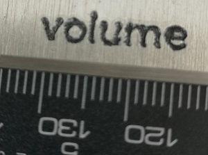 the word volume engraved in aluminium